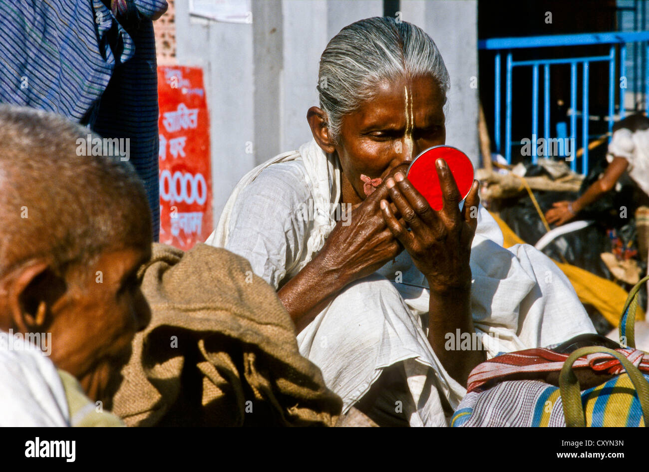 Femme Krishna-Sadhu appliquant son tilak dans le cadre du matin pooja, Delhi, Inde, Asie Banque D'Images