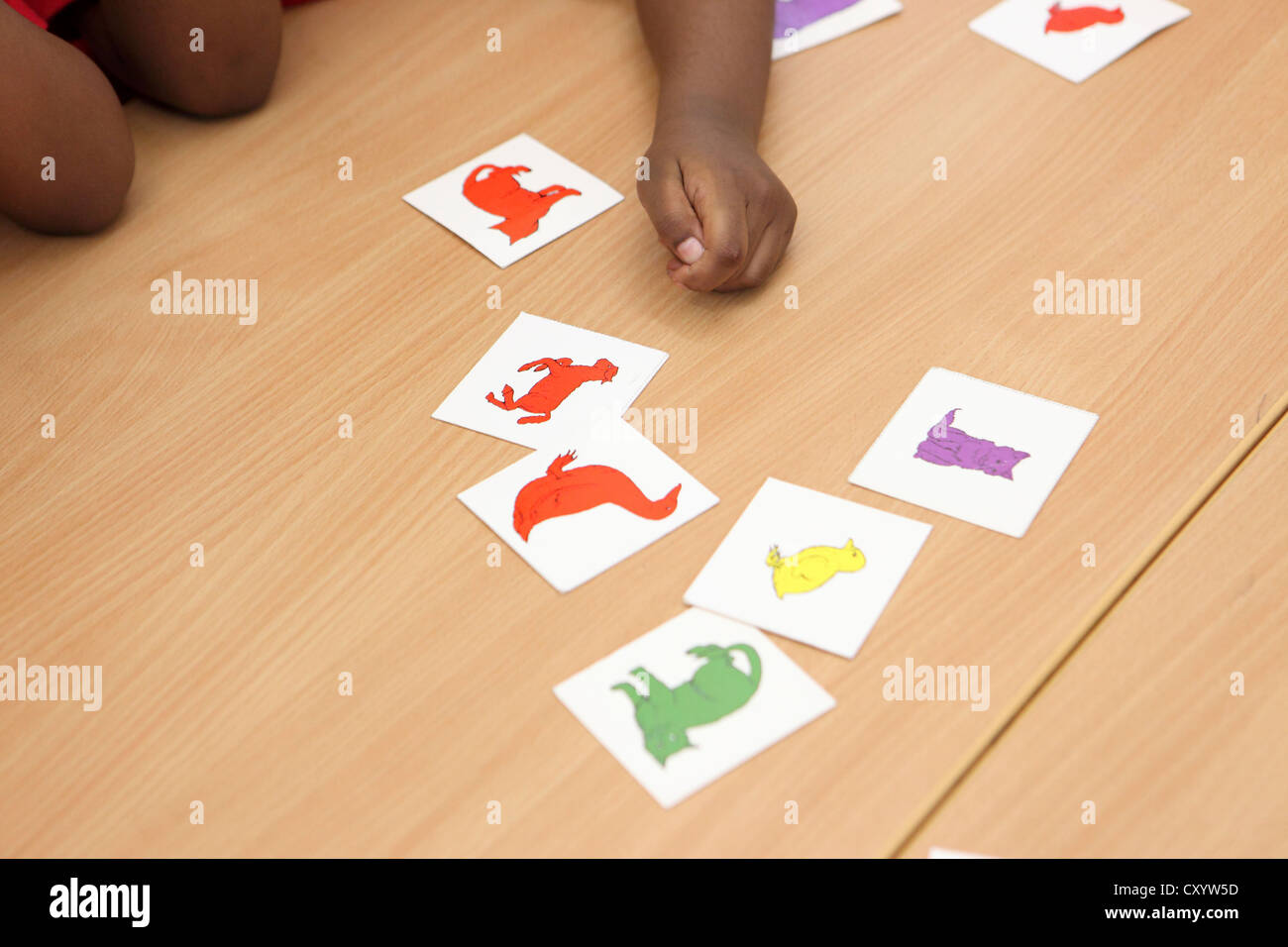 Close-up de la main et du bras de l'enfant, avec des cartes, effectuer des sélections, Londres l'enseignement primaire. Banque D'Images