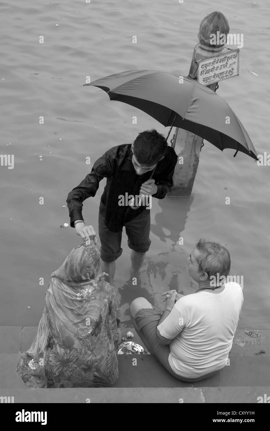 Un hindou Pujari (prêtre) bénit un couple pieux Co. à ghat, Mathura, Inde Banque D'Images