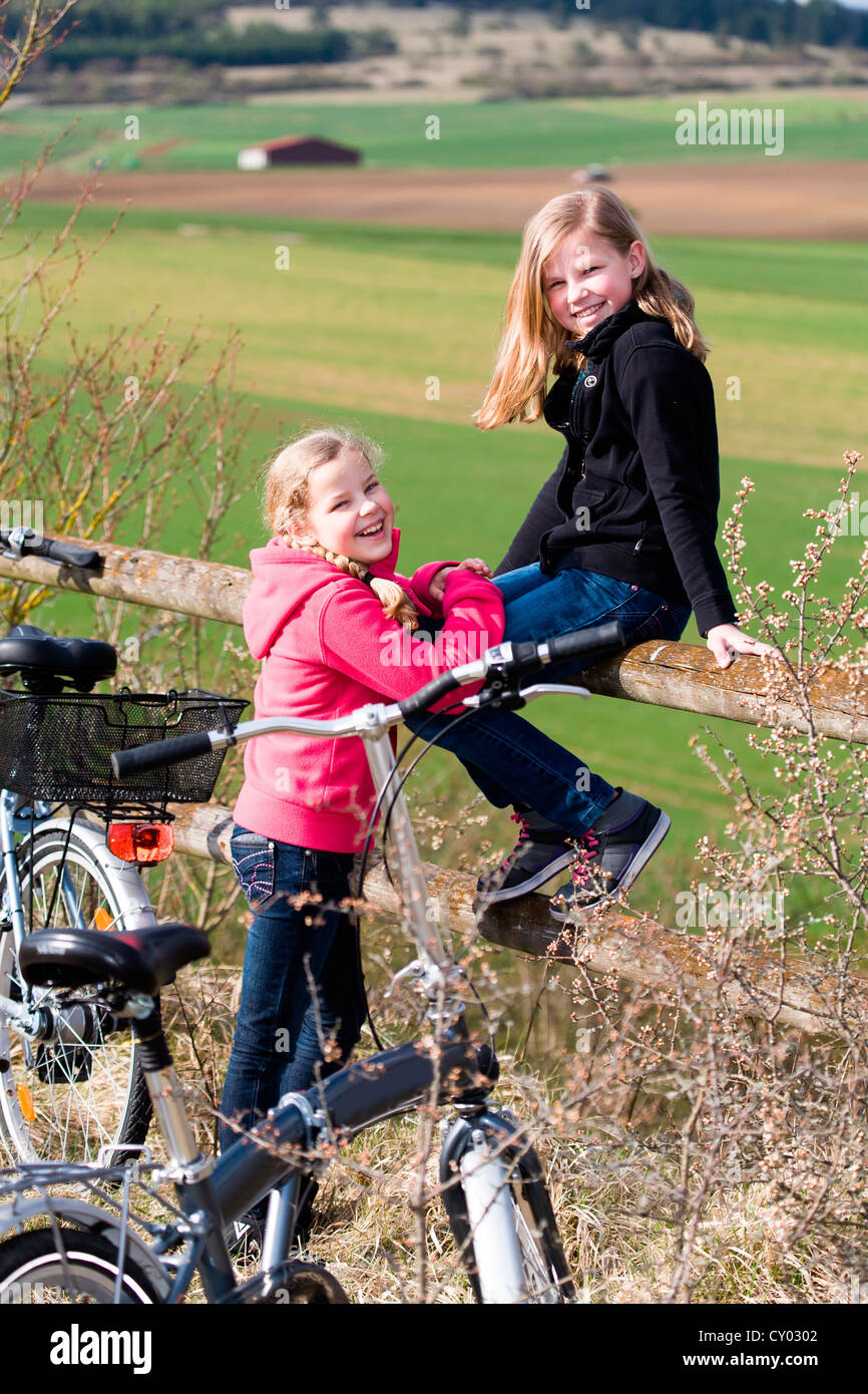 Deux jeunes filles avec des bicyclettes in rural landscape Banque D'Images