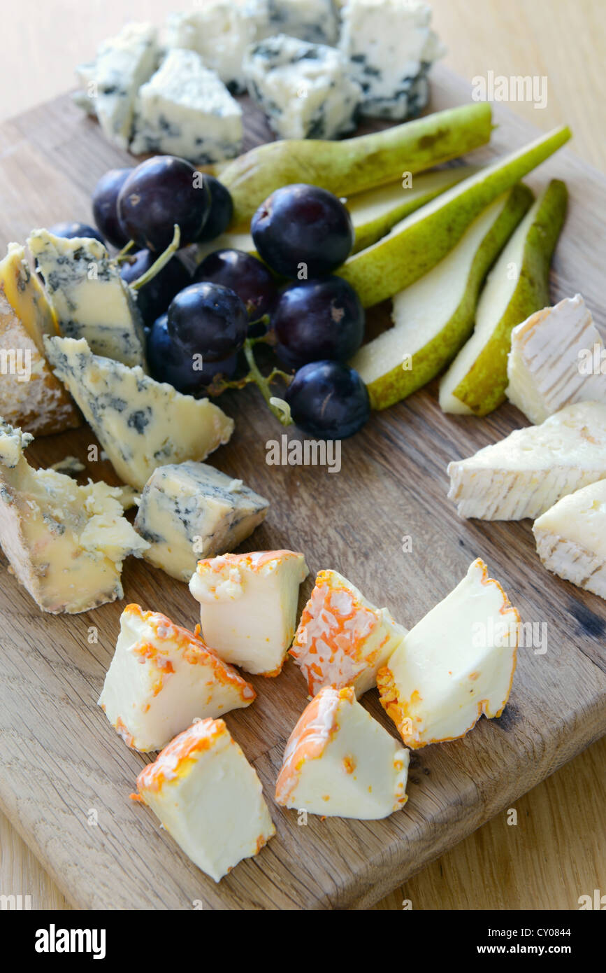 Set de fromage avec le moule sur une planche en bois avec des raisins et des poires Banque D'Images