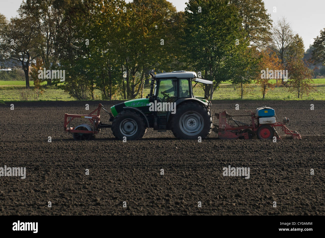 Tracteur avec rouleau avant et une machine de semis à l'arrière sur un champ, Rhénanie du Nord-Westphalie, PublicGround Banque D'Images