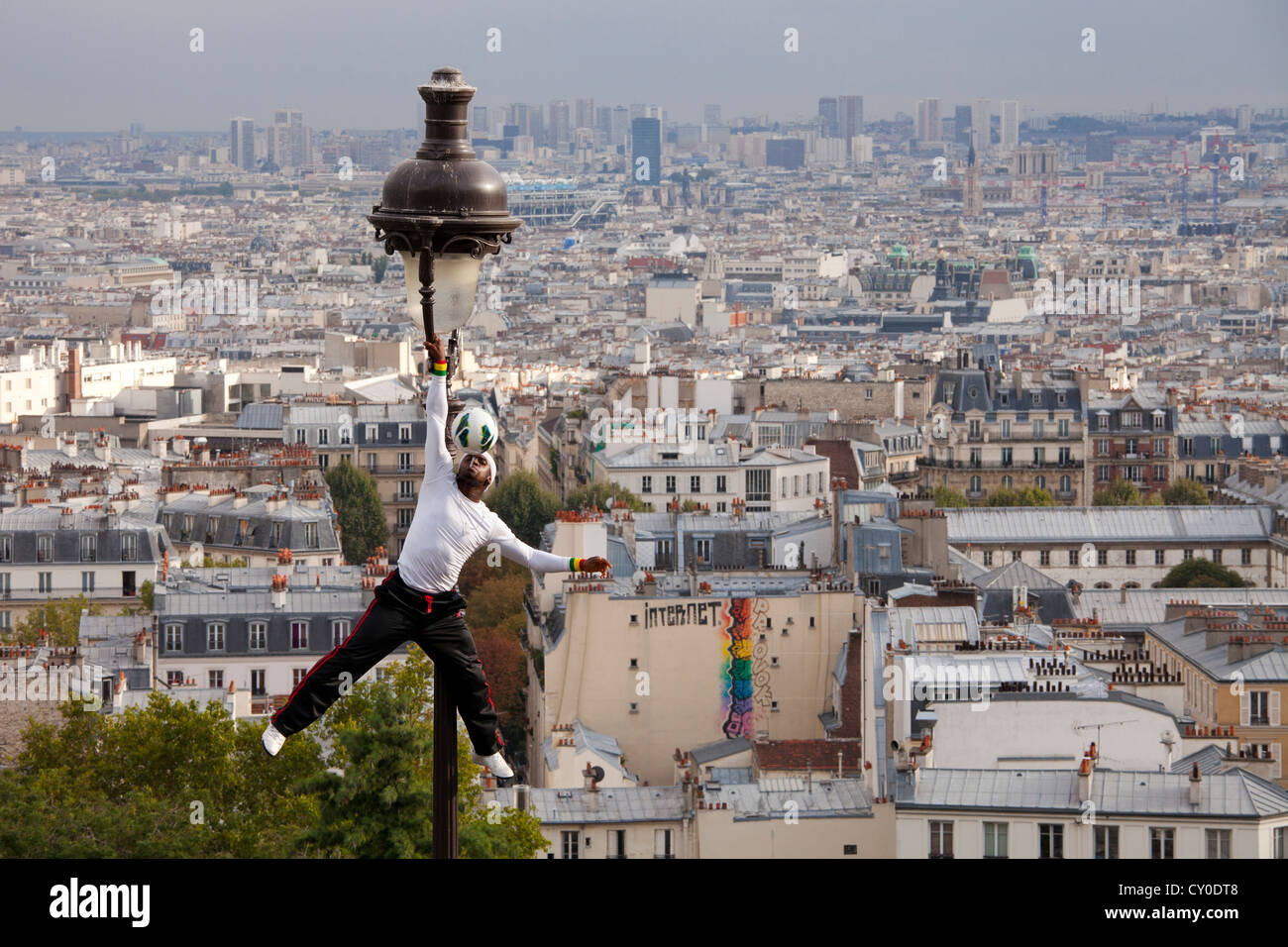 Artiste performance acrobatique sur une vieille lampe de rue sur la colline du Sacré Coeur et de Montmartre et vue Paris Banque D'Images