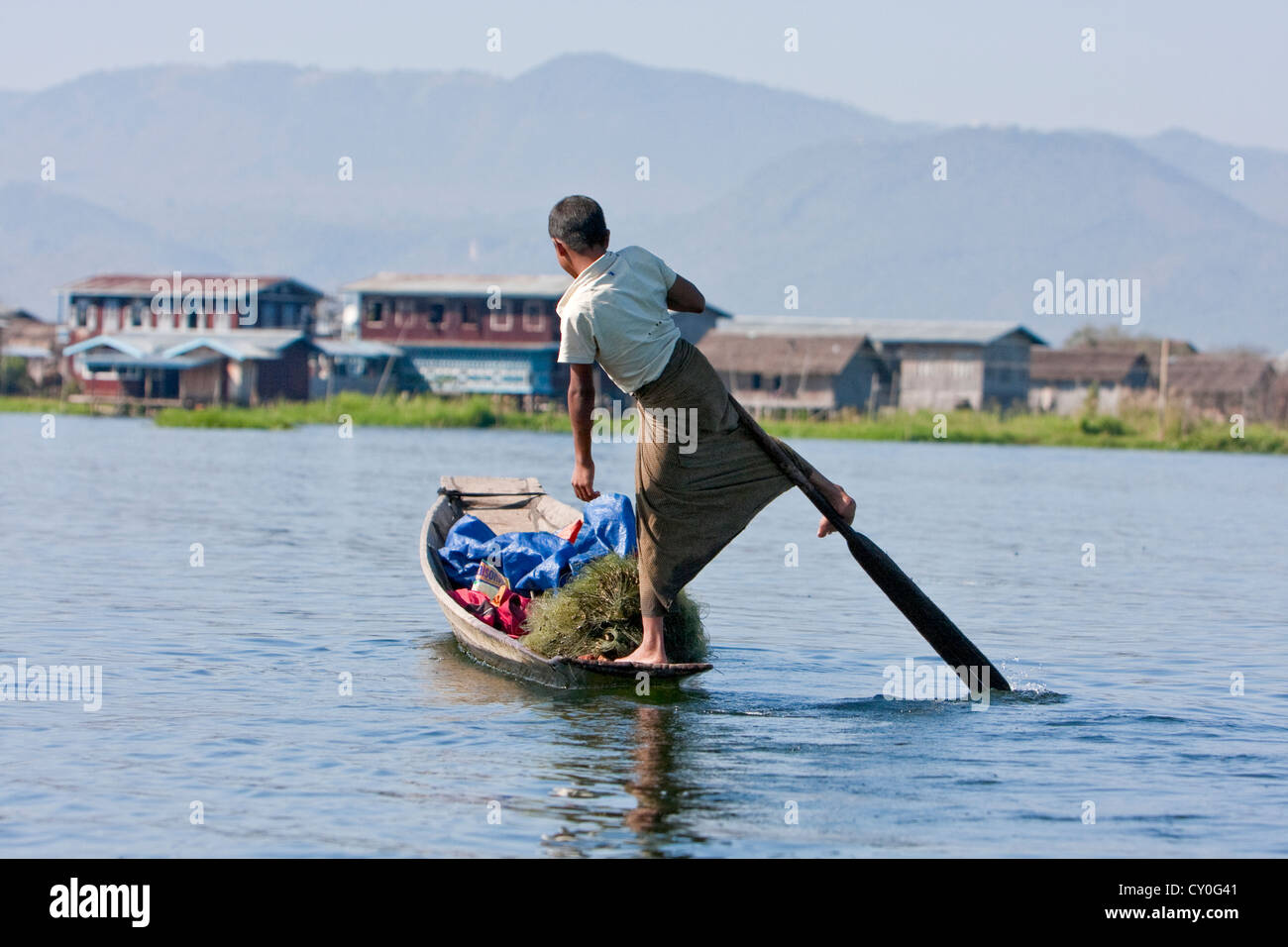 Le Myanmar, Birmanie. Jeune homme avec une jambe, dans le style commun à Lac Inle, l'État Shan. Banque D'Images