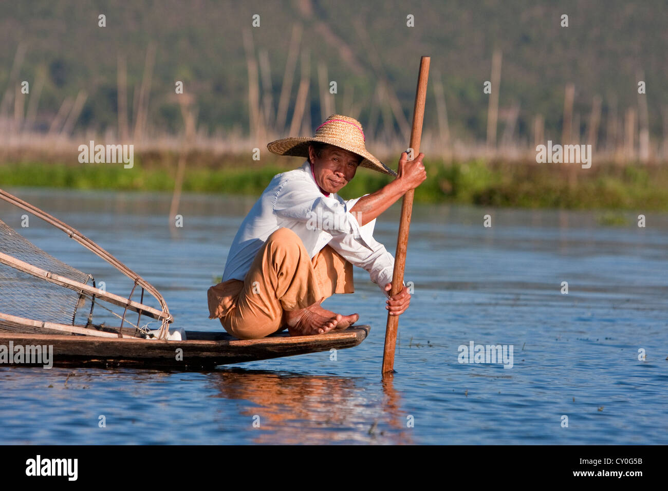Le Myanmar, Birmanie. La préparation de pêcheur de placer son filet sur le fond du lac, au Lac Inle, l'État Shan. Banque D'Images