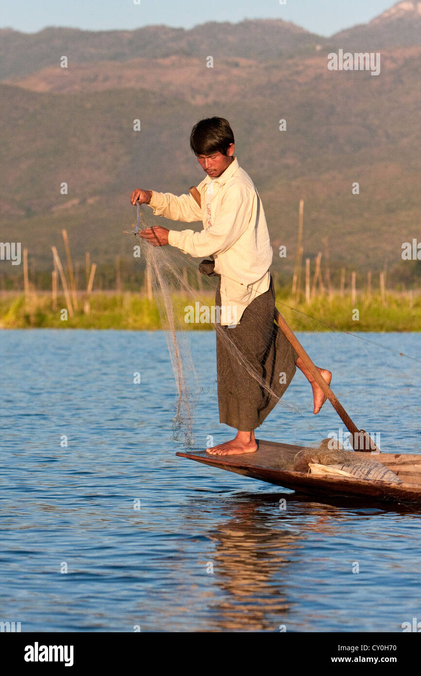 Le Myanmar, Birmanie. Préparer son filet de pêcheur comme il en équilibre sur une jambe, dans le style commun à Lac Inle, l'État Shan. Banque D'Images