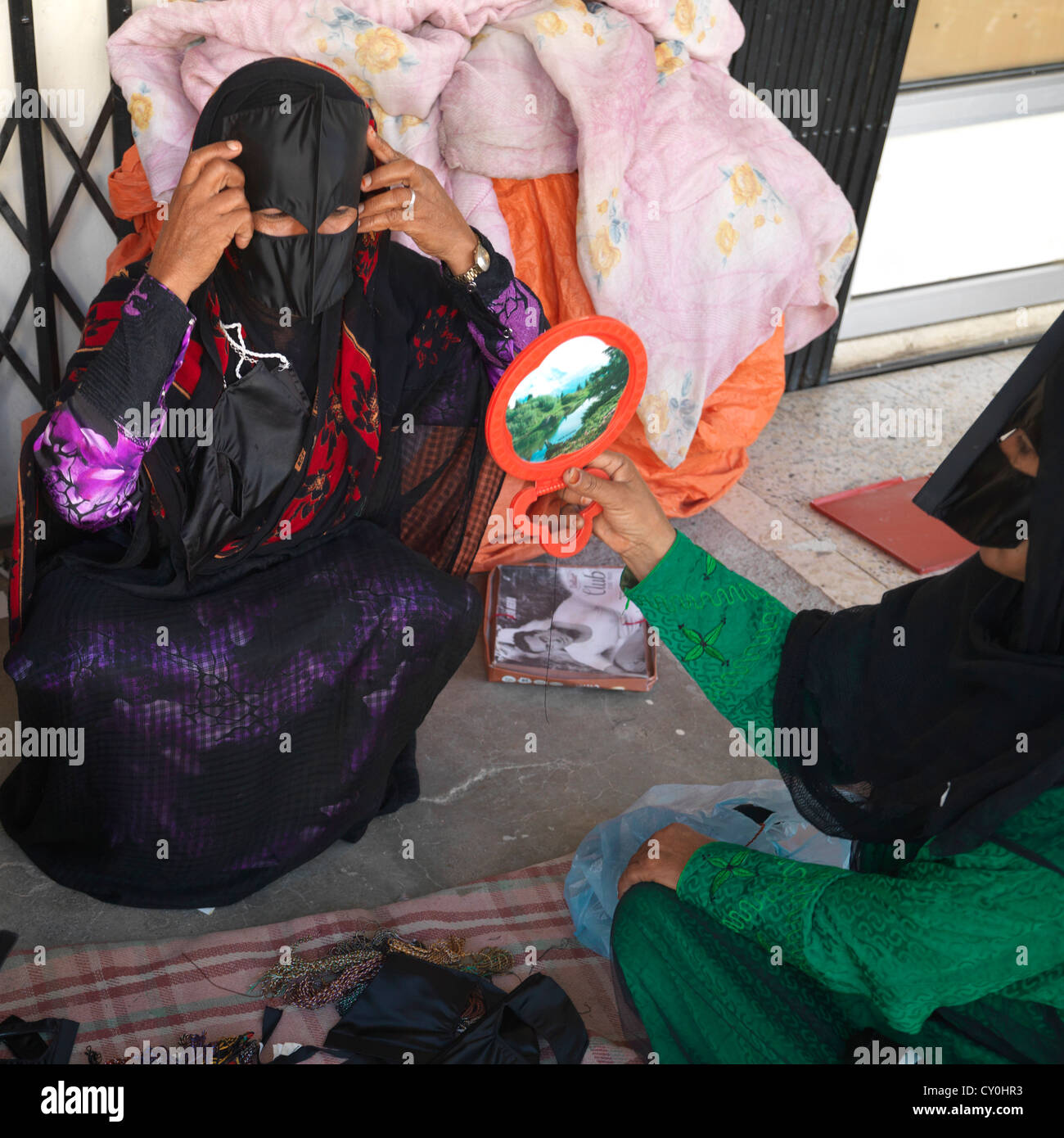 Bédouine à la recherche dans le miroir, Sinaw, Oman Banque D'Images