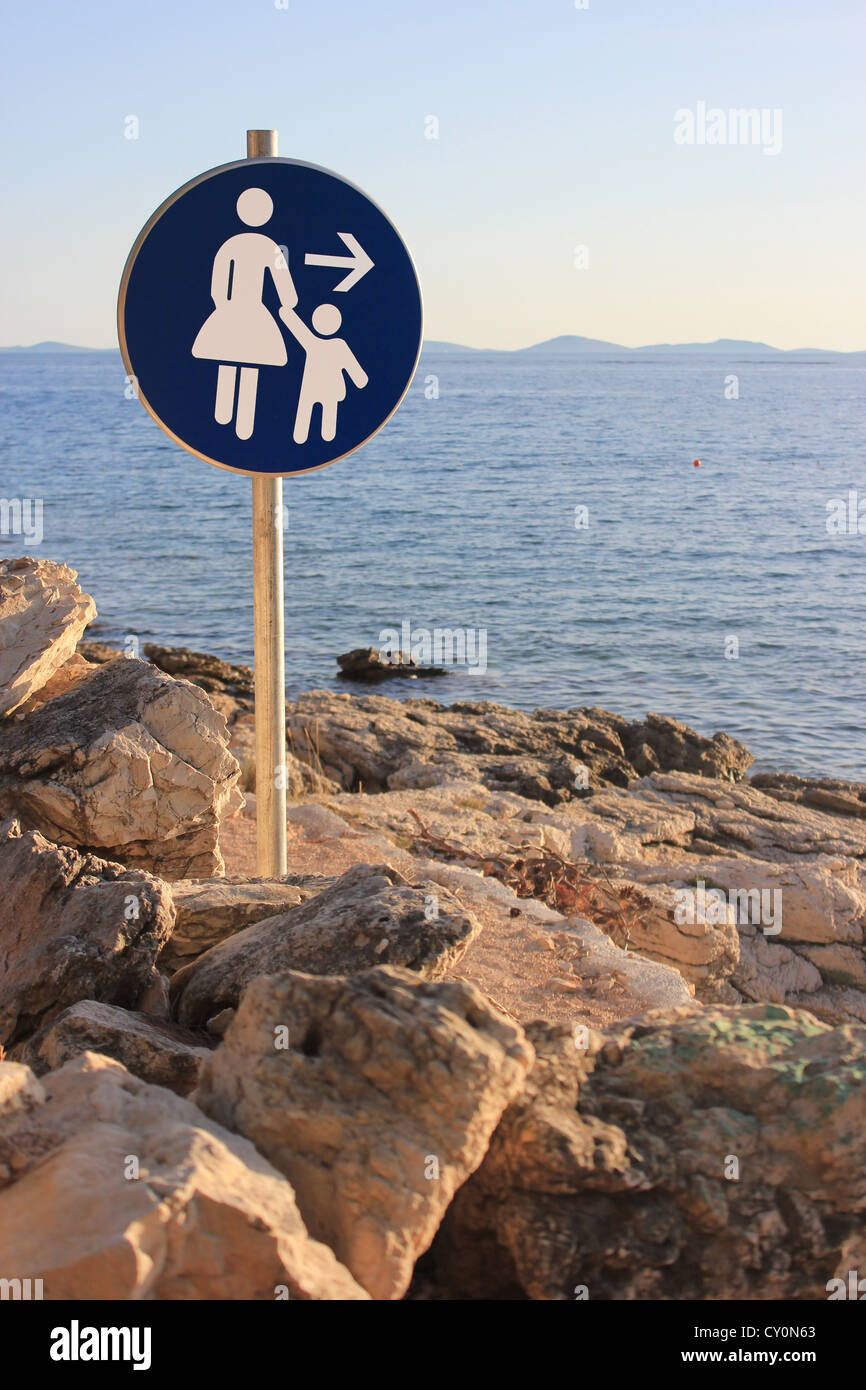 Femme et enfant direction - signe de la circulation chemin de bord de mer Banque D'Images