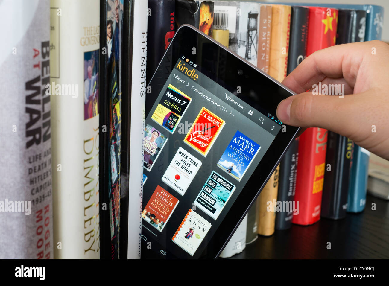 Google Nexus 7 tablet computer avec kindle e-book library application et durée de 29,7 livres papier traditionnel Banque D'Images