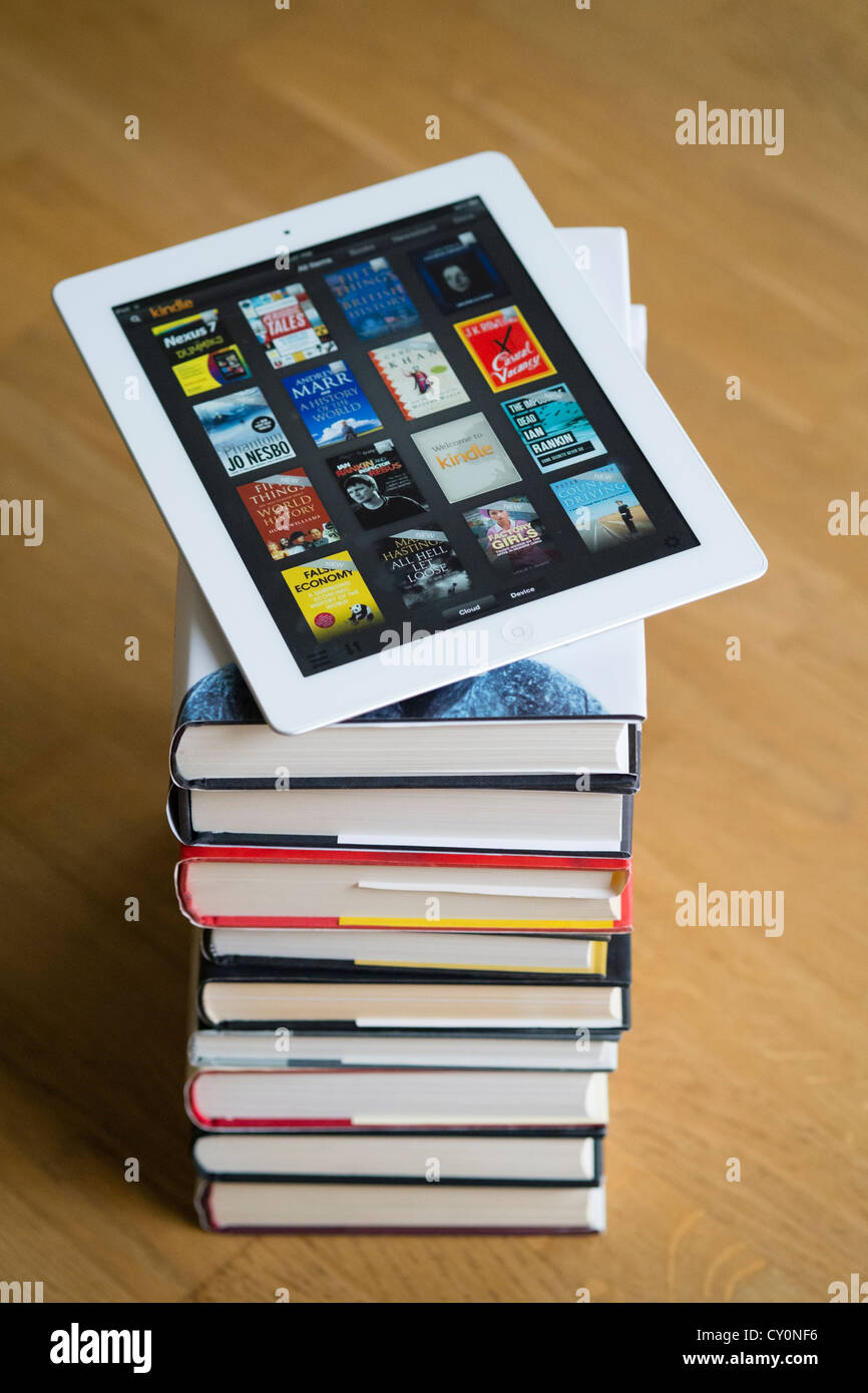 Avec l'ordinateur tablette iPad kindle e-book library application et pile de livres papier brochée traditionnels Banque D'Images