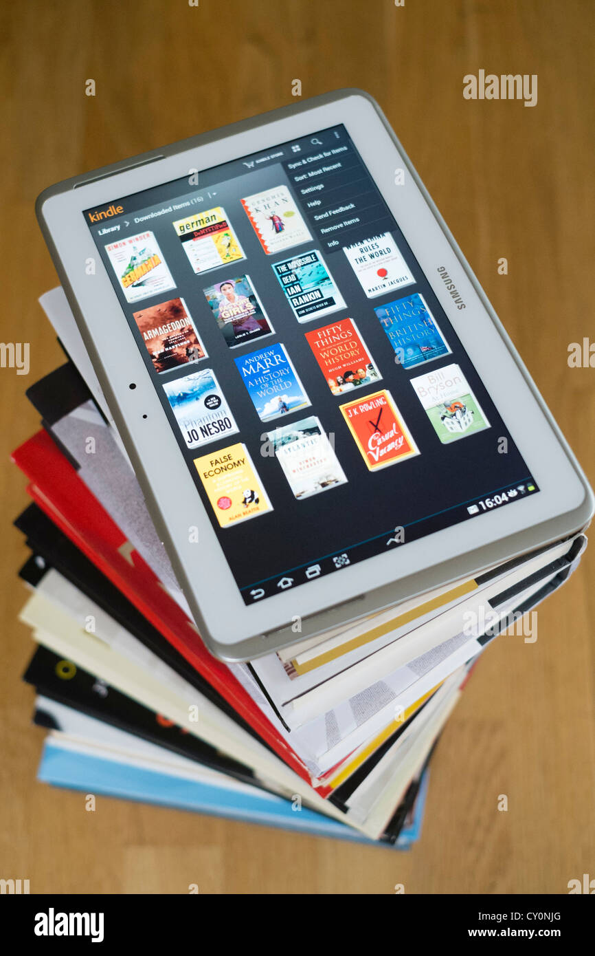 Tablette Samsung Galaxy Note 10 ordinateur avec kindle e-book library application et pile de livres papier brochée traditionnels Banque D'Images