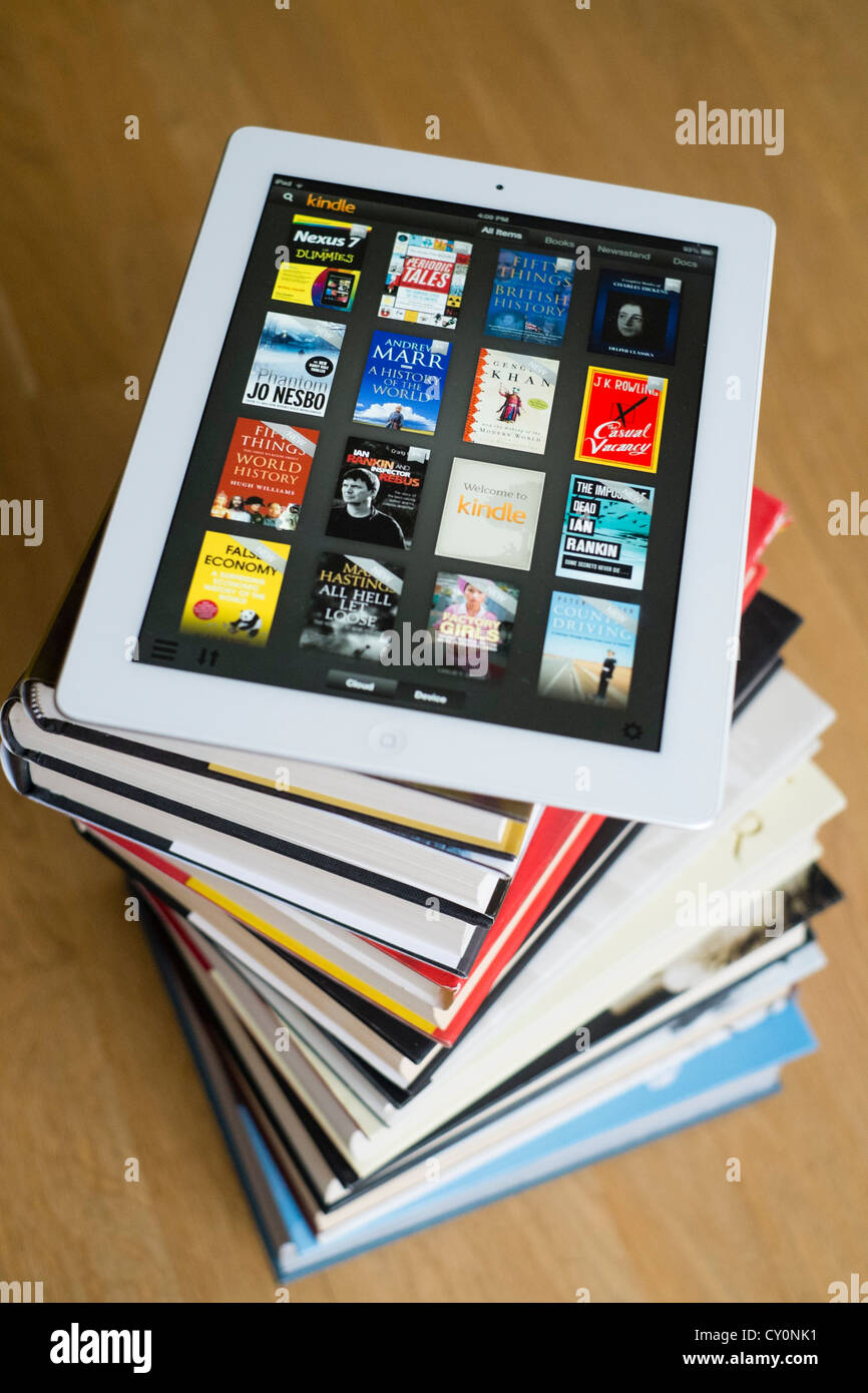 Avec l'ordinateur tablette iPad kindle e-book library application et pile de livres papier brochée traditionnels Banque D'Images