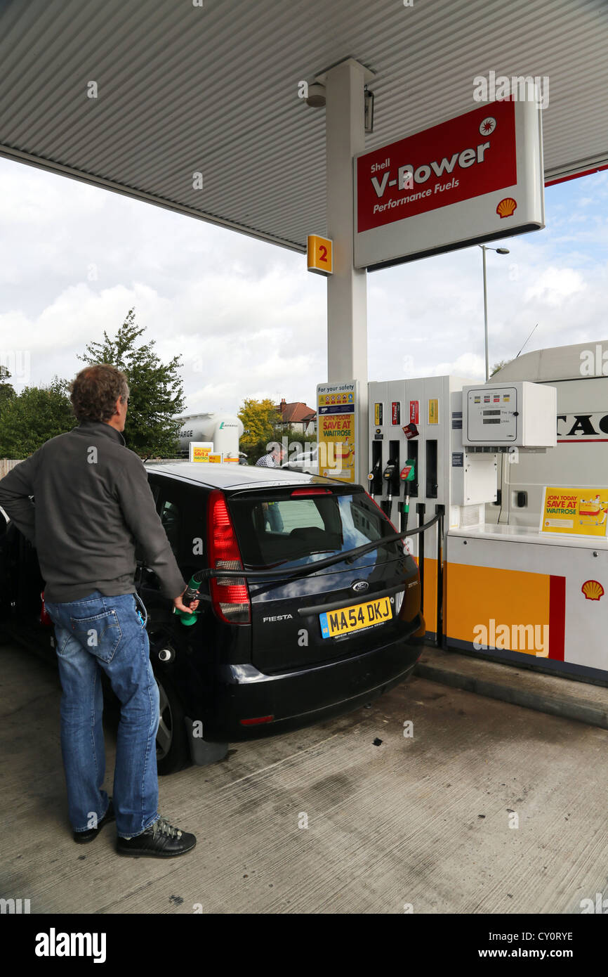 Man Filling Up Ford Fiesta avec l'essence ordinaire sans plomb aux stations d'essence Shell Angleterre Ewell Banque D'Images