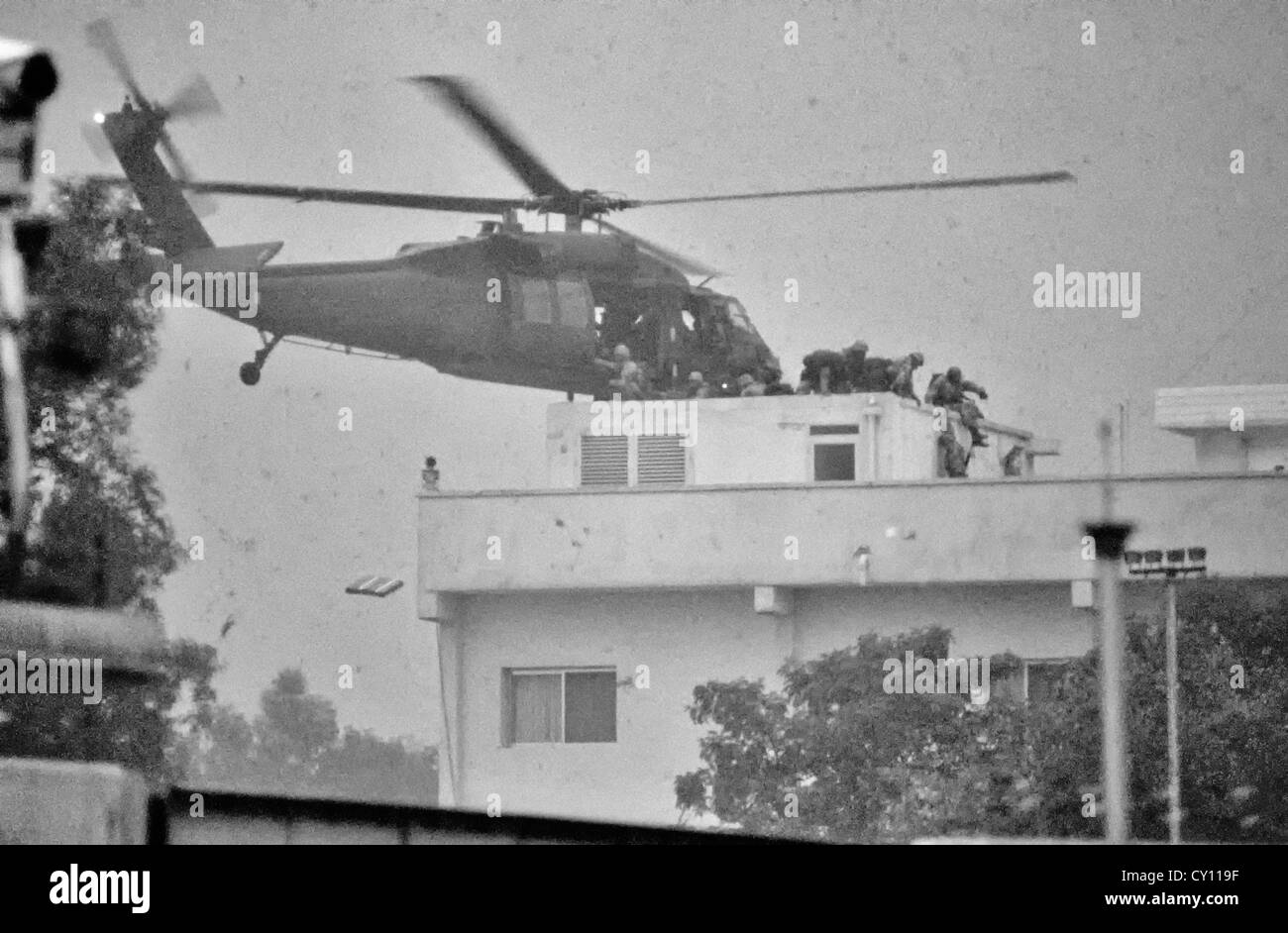 Les forces spéciales des États-Unis sautent d'un hélicoptère Blackhawk sur le toit de l'ambassade des États-Unis alors qu'elles ont repris le bâtiment après la libération du pays de l'occupation irakienne lors de l'opération tempête du désert, à 28 février 1991, dans la ville du Koweït. Le ciel est obscurci par la fumée des feux de pétrole qui couvrent la ville. Banque D'Images