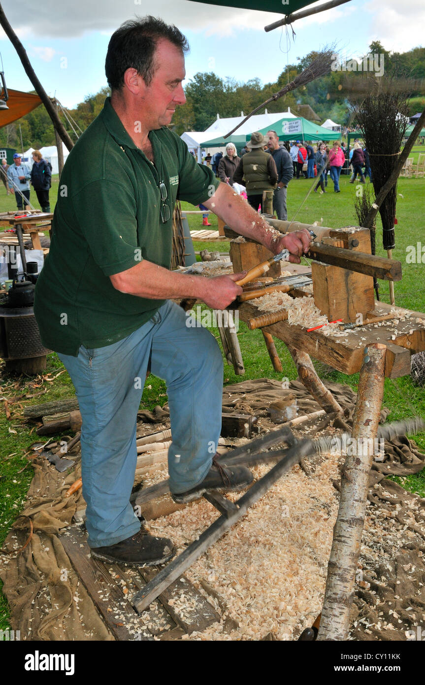 Homme démontrant le Pole Lathe tournant sur un tour à pédale, faisant des manches à brosse au salon de la campagne d'automne, West Sussex, Angleterre, Royaume-Uni Banque D'Images