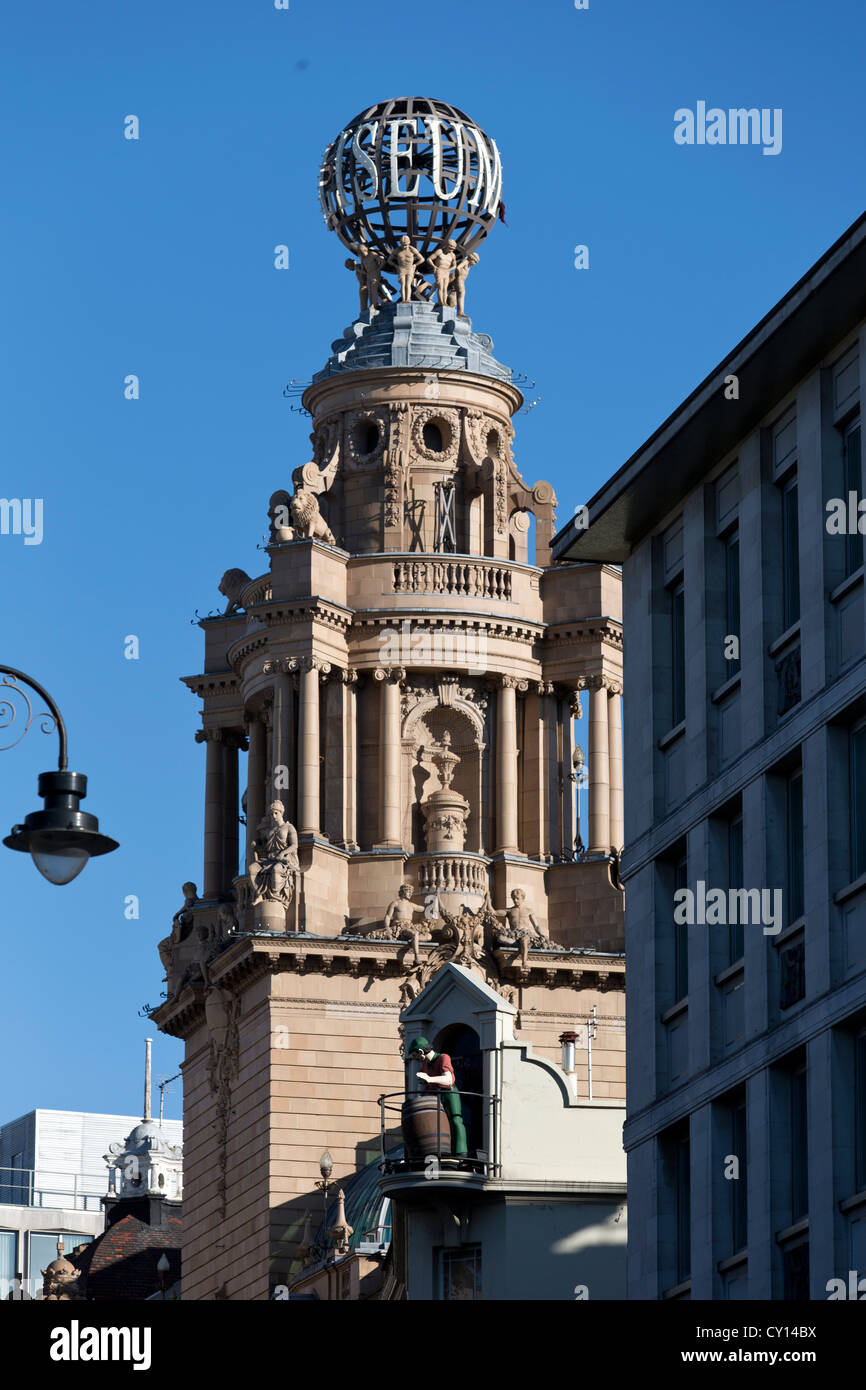 Le London Coliseum Theatre & une sculpture d'un homme & Beer Barrel sur le haut Chandos Pub. Trafalgar Square, Londres, Royaume-Uni. Banque D'Images