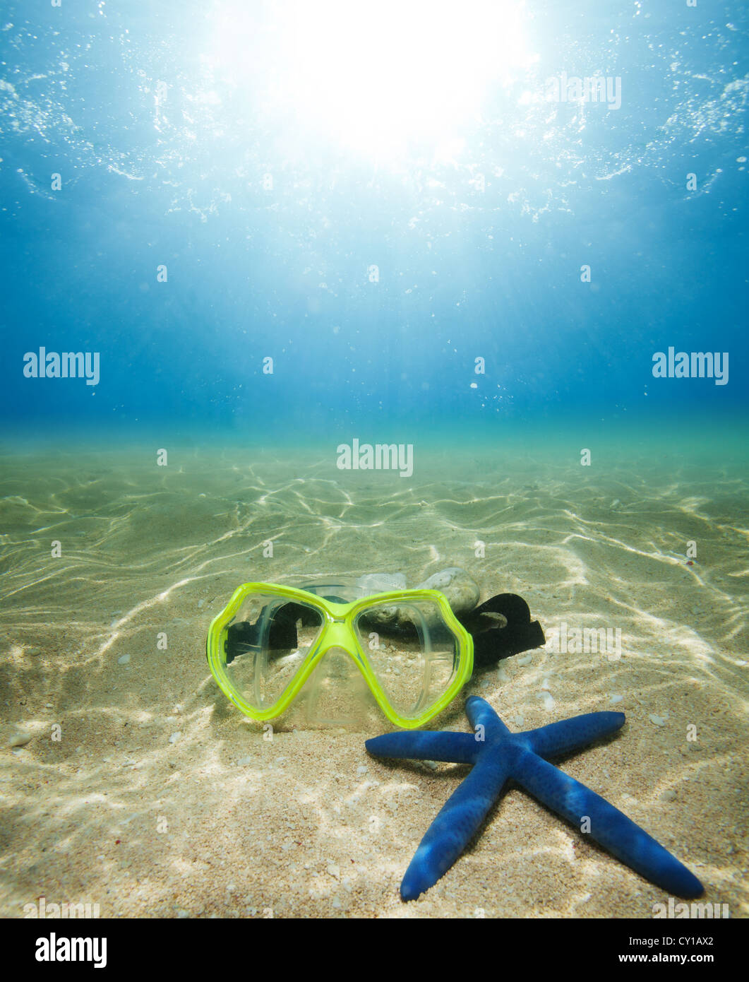 Masque de plongée sous-marine et des étoiles de mer sur le sable avec la lumière du soleil Banque D'Images