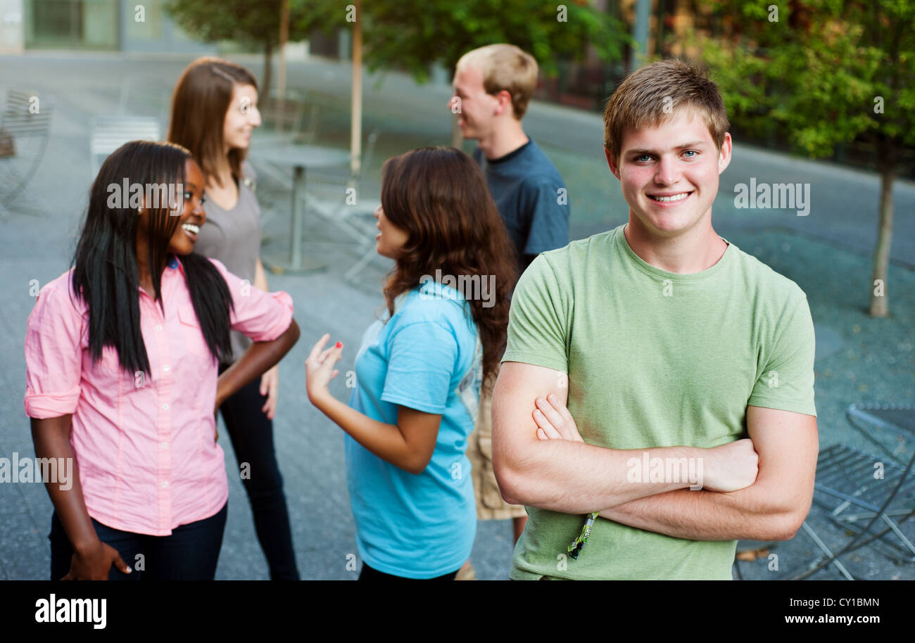 Jeune homme souriant avec des amis dans l'arrière-plan Banque D'Images