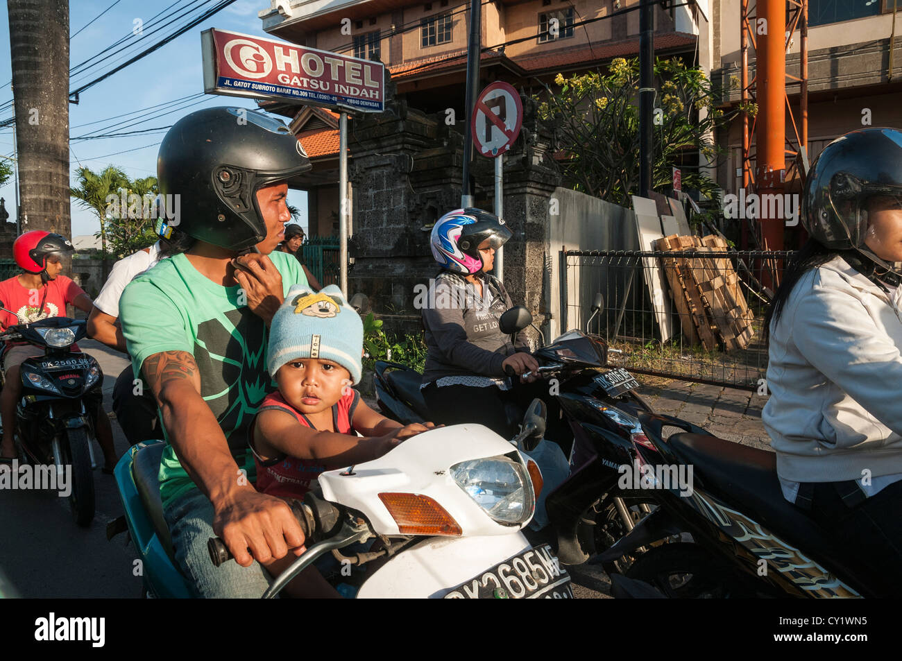 Enfant sur un cyclomoteur sur la rue principale de Legian, Legian, du sud de Bali, Indonésie. Banque D'Images