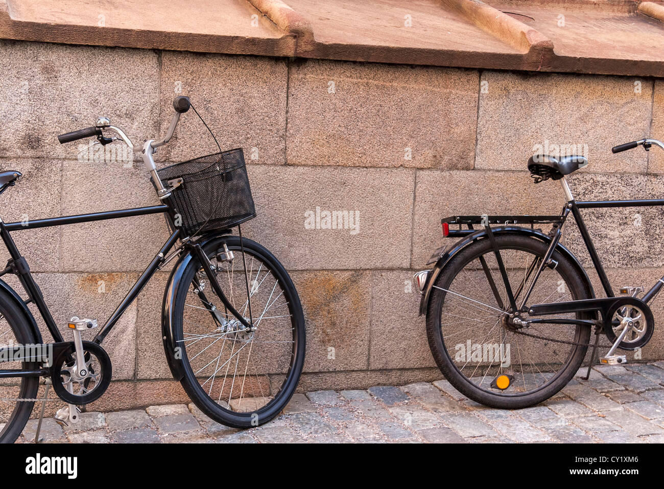 Deux vieux vélos classiques près du mur de pierre Banque D'Images