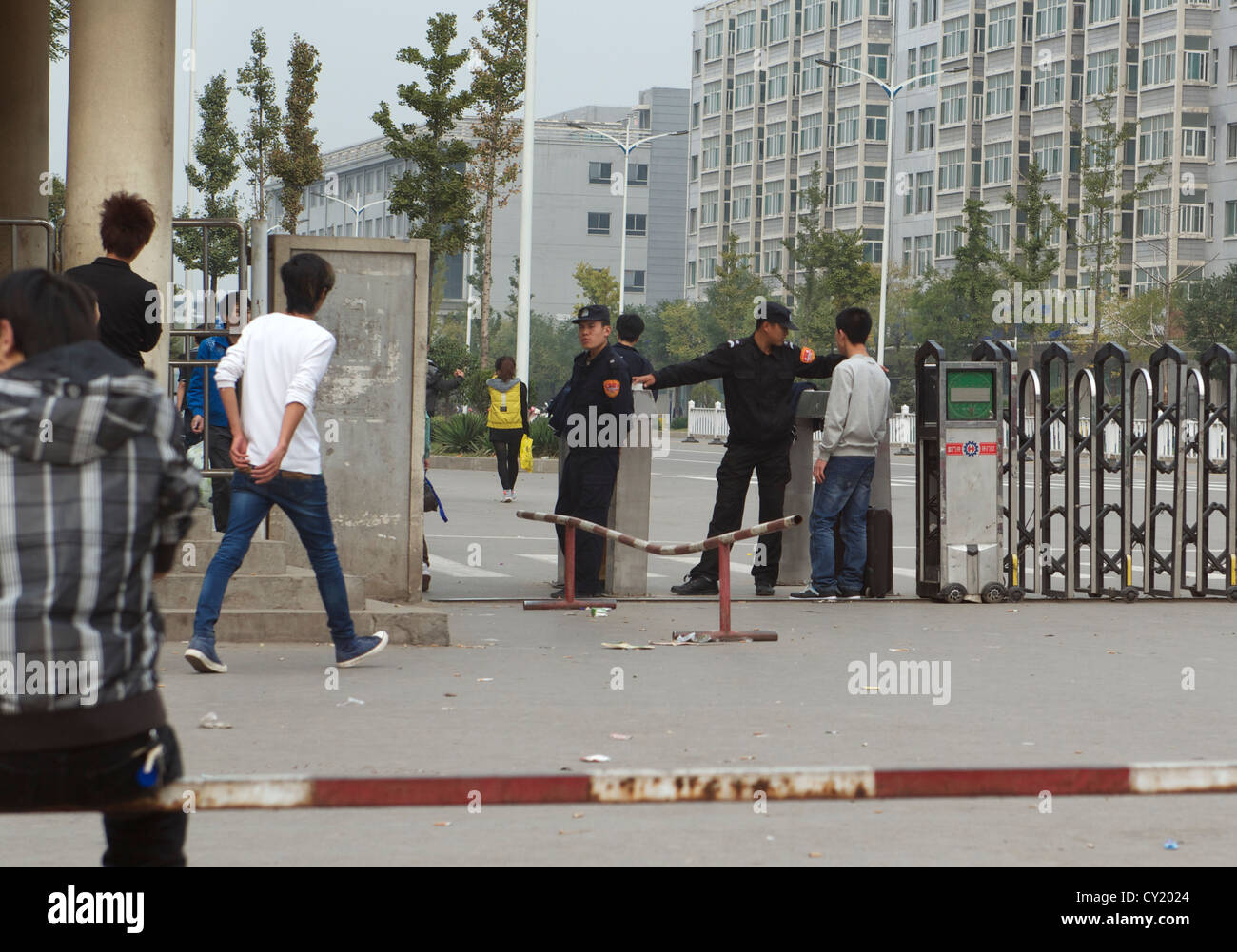 Les gardes de sécurité bloquer un travailleur qui a oublié de porter sa carte d'accès à la porte n°3 de l'usine Foxconn de Taiyuan, Shanxi, en Chine. 2012 Banque D'Images