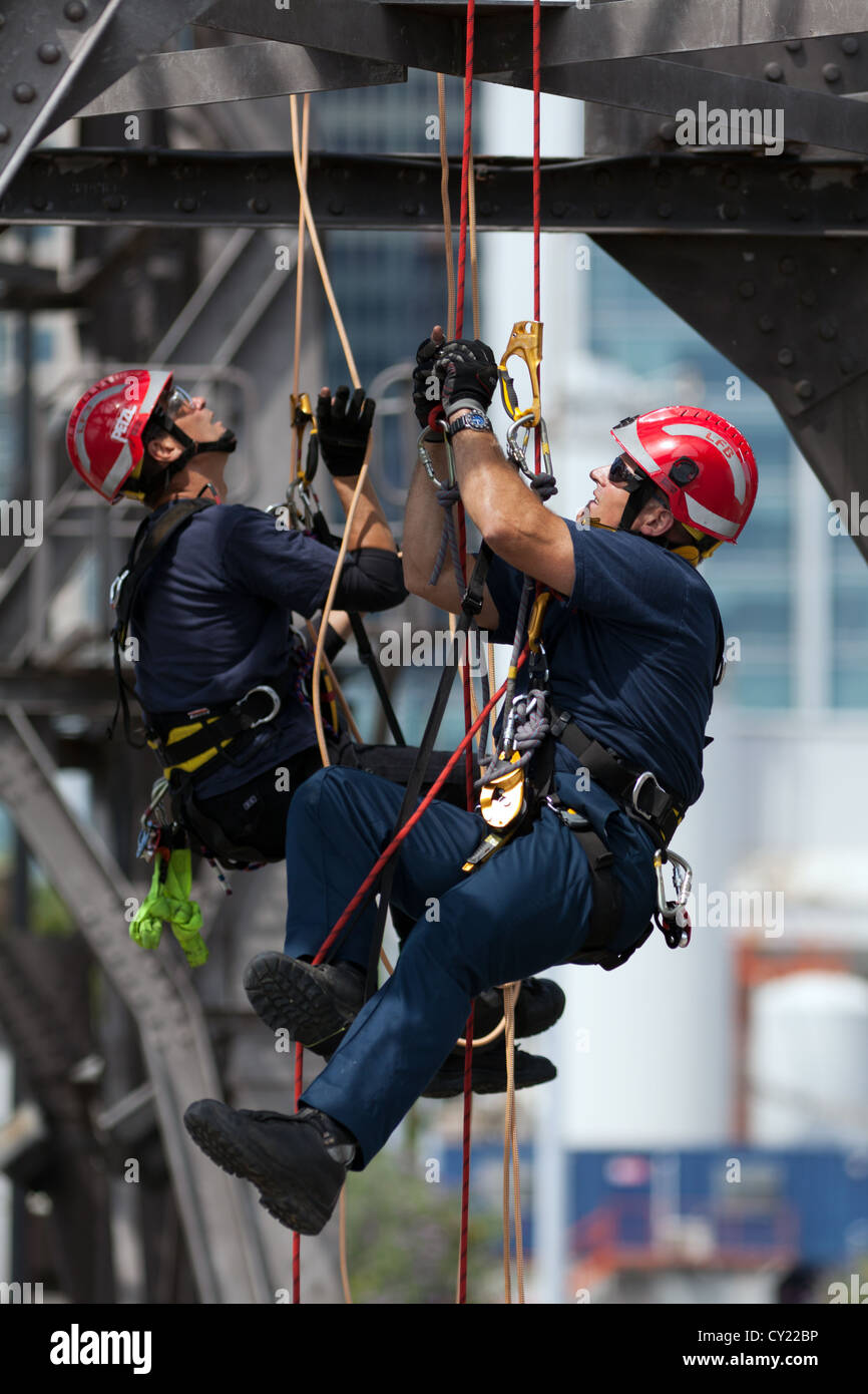 Les membres de London Fire Brigade des procédures de sauvetage par câble pratique sur la vieille grue dans les Docklands de Londres. Banque D'Images