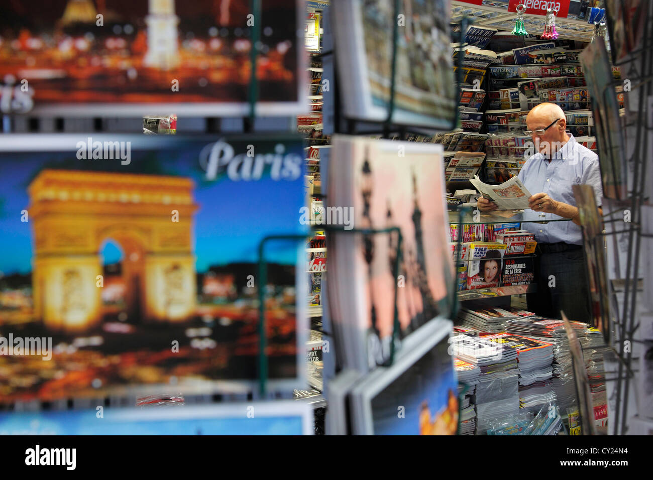 Vendeur lire un journal à son stand à Paris Banque D'Images