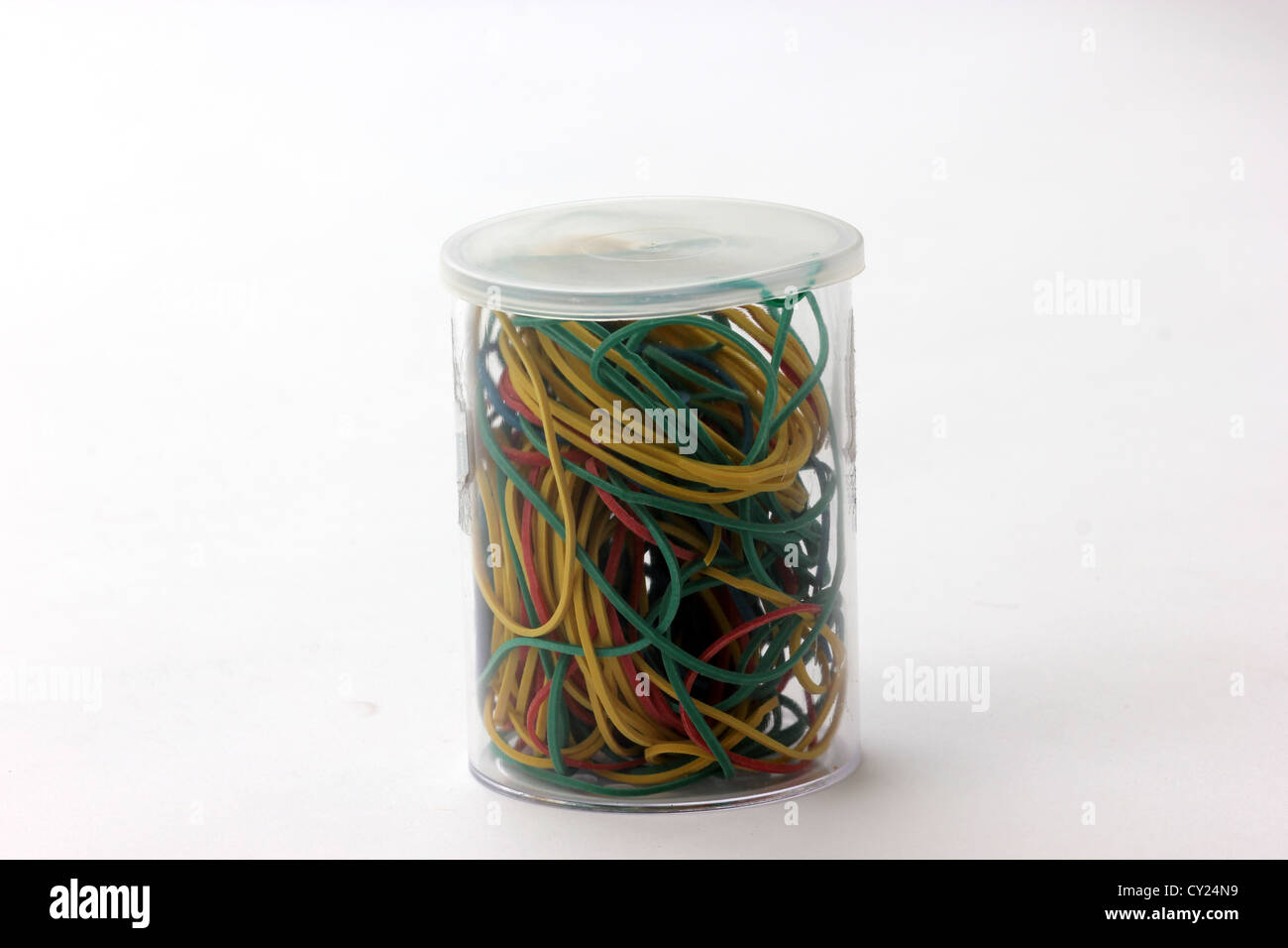 Les bandes en caoutchouc de couleur dans un contenant de plastique sur un fond blanc, photoarkive Banque D'Images