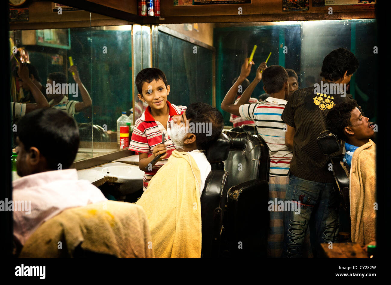 Garçon coupant des cheveux et se raser dans une barbiche du Bangladesh Banque D'Images