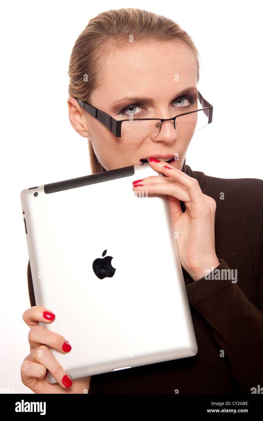 Blonde woman wearing glasses mordant sa nerveux i pad avant une réunion Banque D'Images
