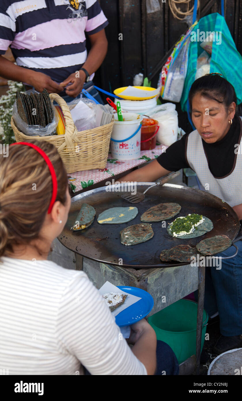 Maïs bleu femme Tlayudas et Quesidillas sur Comal à la Jamaïque marché dans la ville de Mexico Banque D'Images