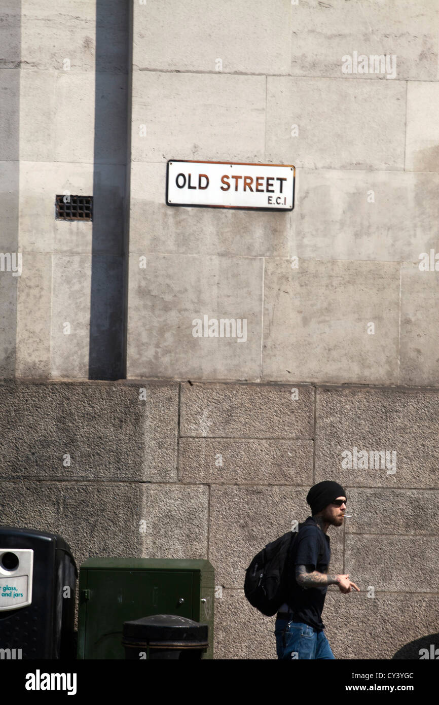 Un jeune homme habillé à la mode ancienne promenades le long de la rue Hoxton square. Hackney, Londres UK Banque D'Images