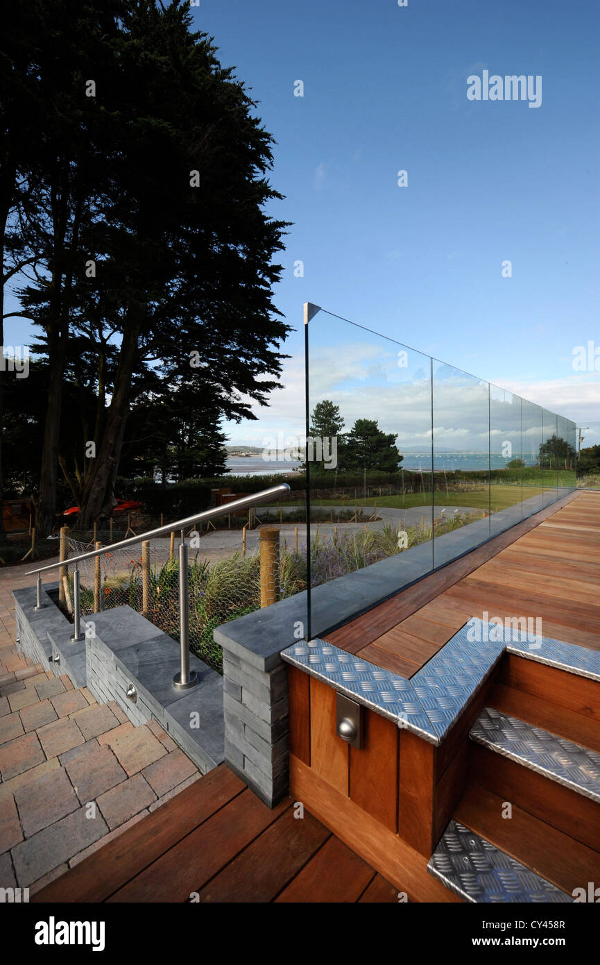 Une terrasse en bois avec balustrade en verre à une maison de vacances de luxe à proximité de la péninsule de Lleyn Abersoch dans le Nord du Pays de Galles UK Banque D'Images