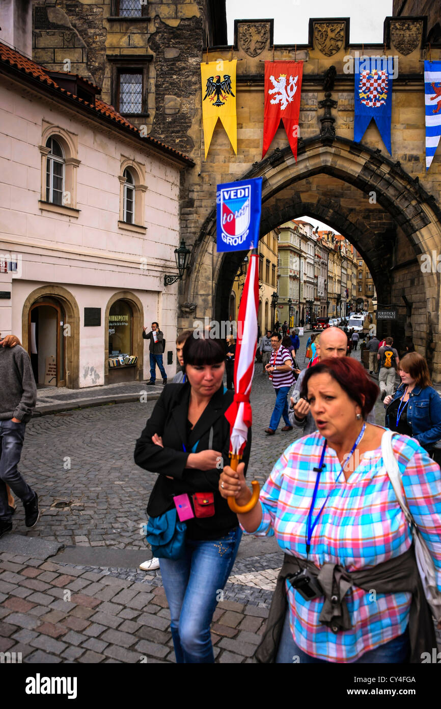 Guide touristique avec son parapluie à la tête d'un groupe à travers le Pont Charles Prague Banque D'Images