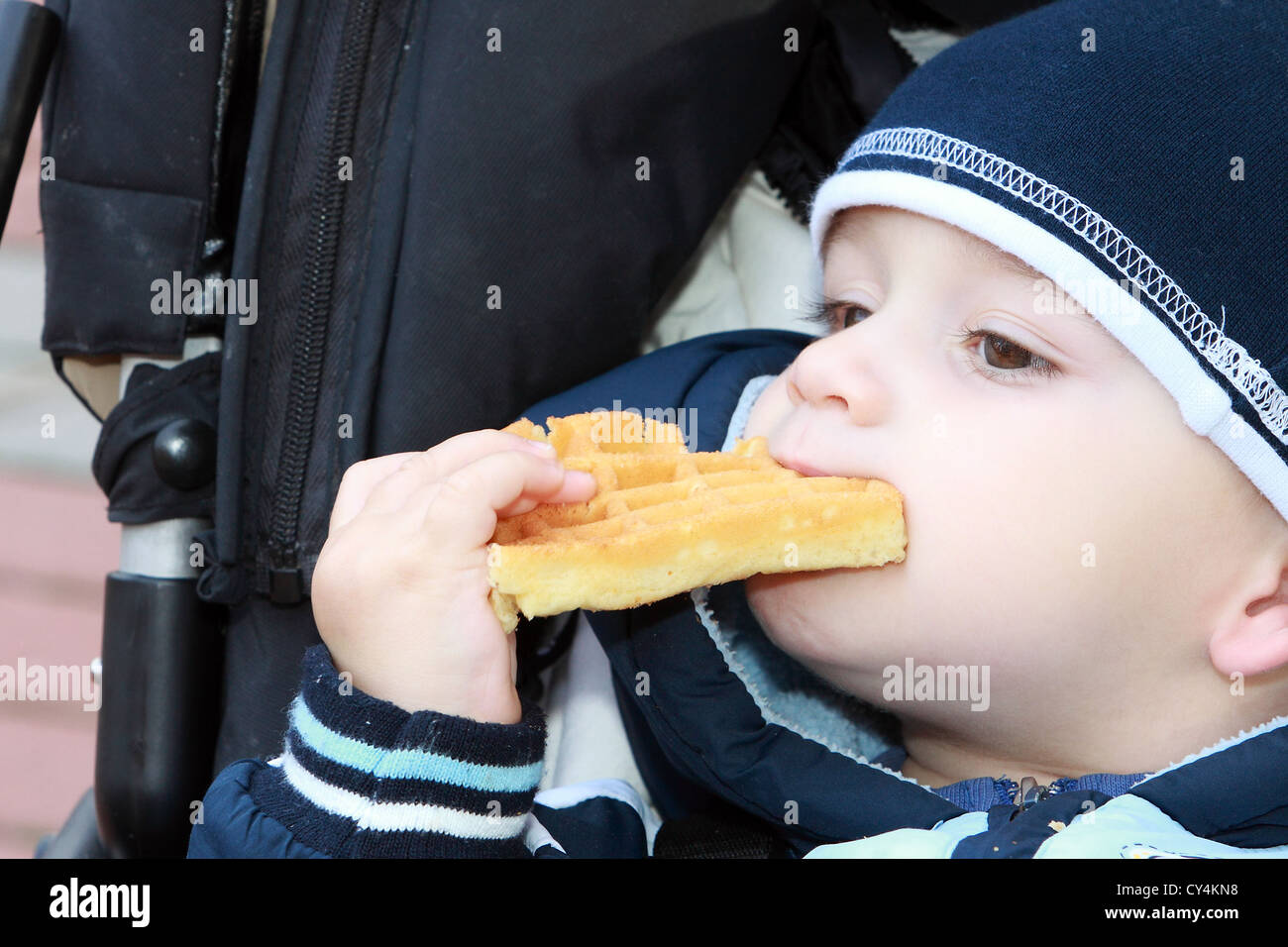 Bébé garçon manger waffle Banque D'Images