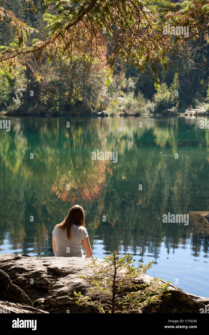 Une jeune femme assise à côté de lac Cresta (Crestasee), Flims, Grisons Suisse Europe Banque D'Images