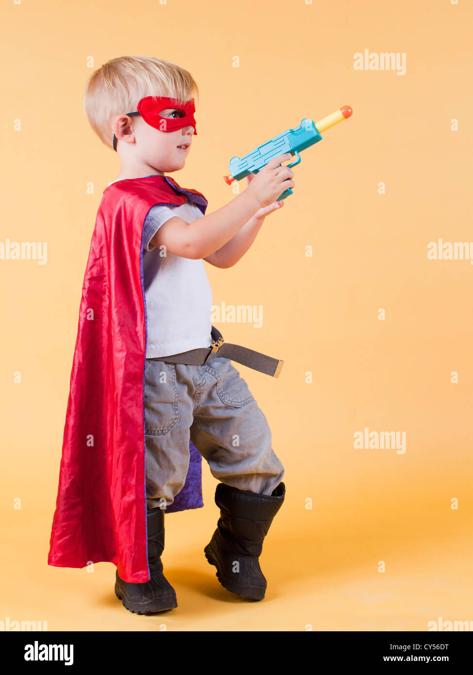 Studio shot, Portrait of boy (2-5 ans) le port de cape et la tenue d'arme-jouet Banque D'Images