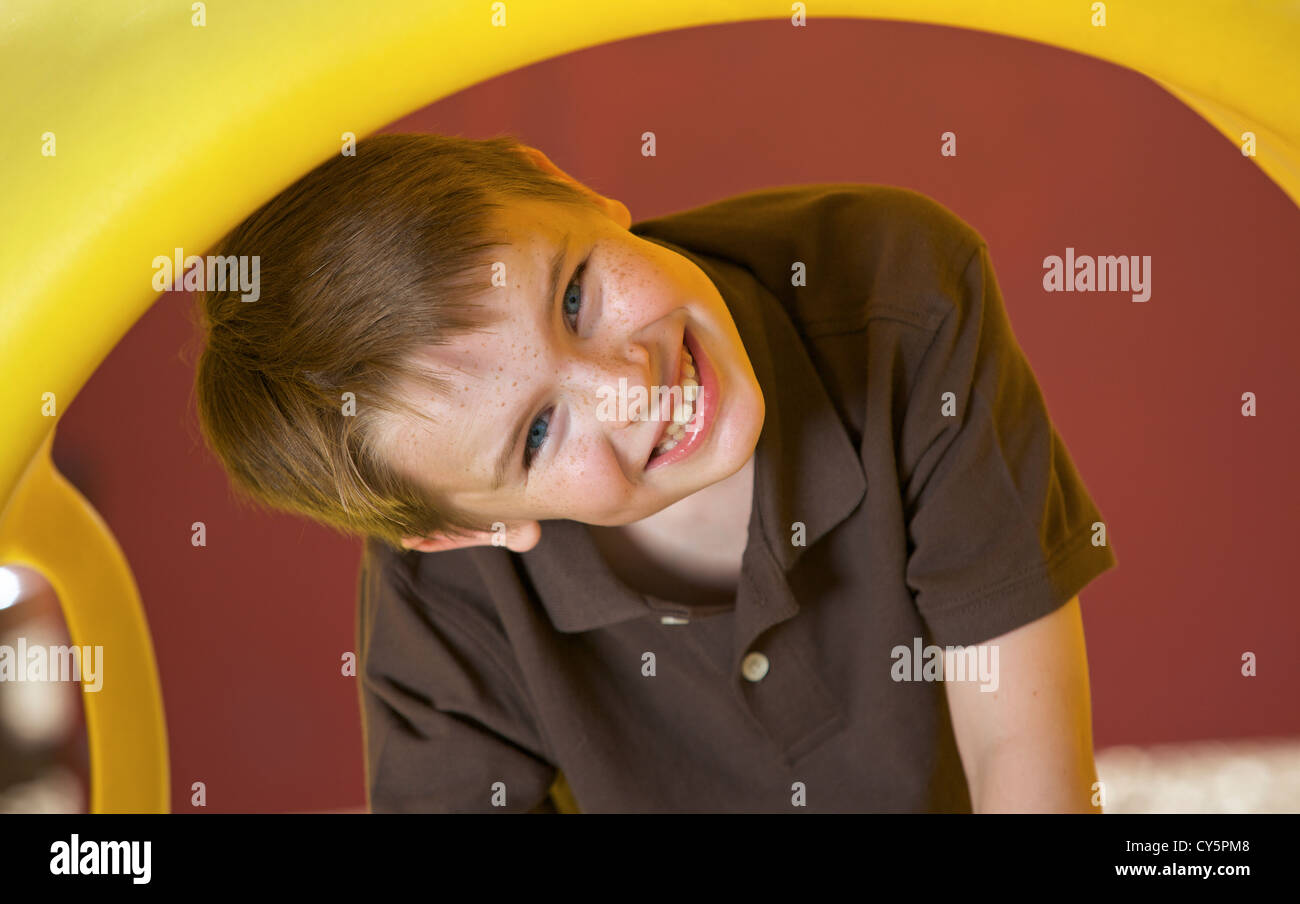 Young Caucasian boy s'amusant à jouer sur l'aire de jeux Banque D'Images