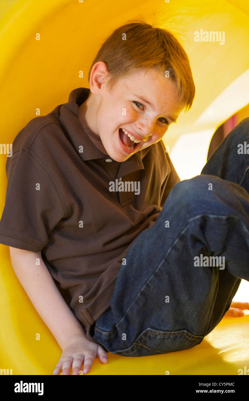 Young Caucasian boy s'amusant à jouer sur l'aire de jeux Banque D'Images
