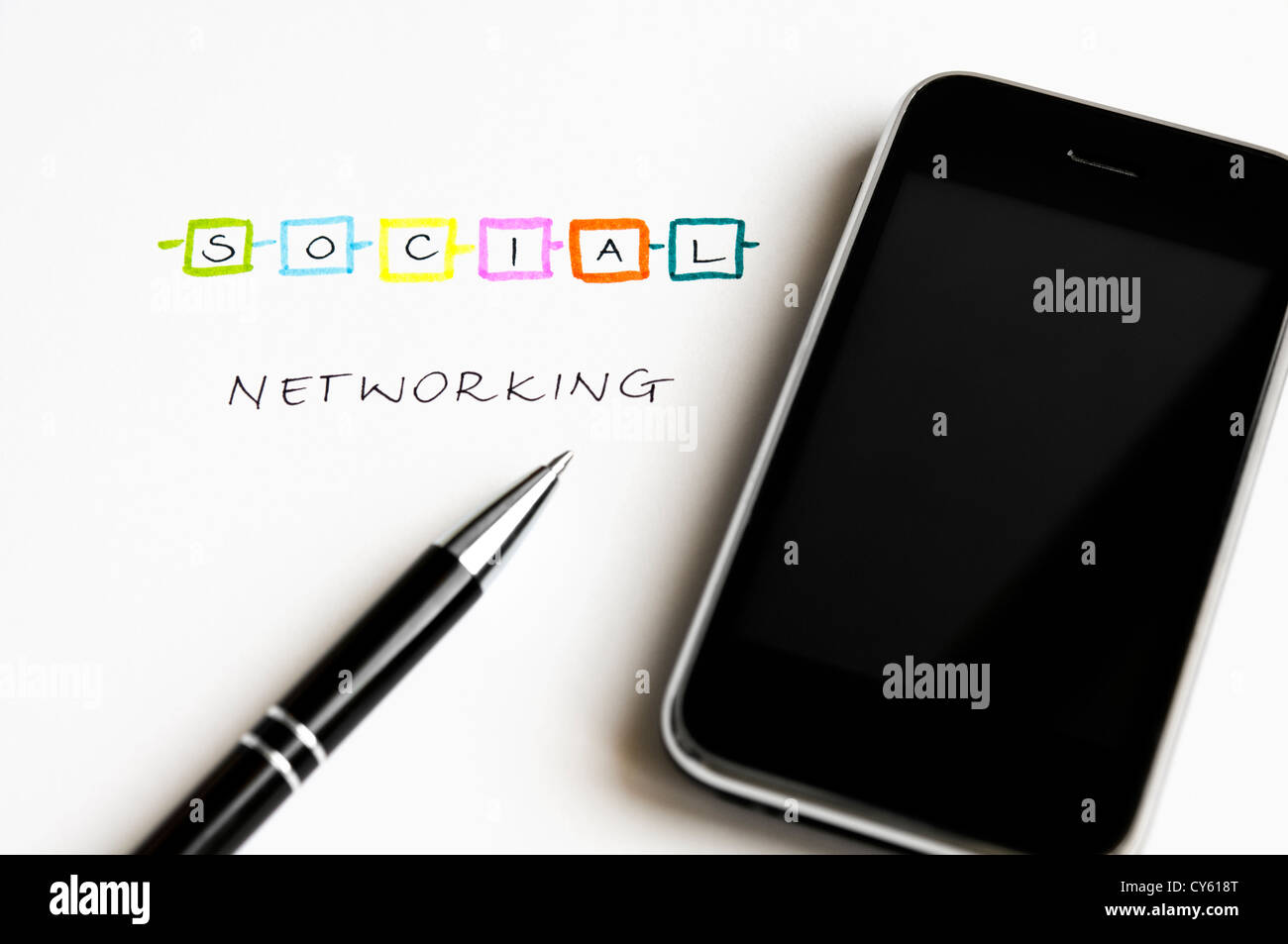 Concept de réseau social avec des lettres colorées, écran tactile moderne téléphone mobile et stylo à bille Banque D'Images