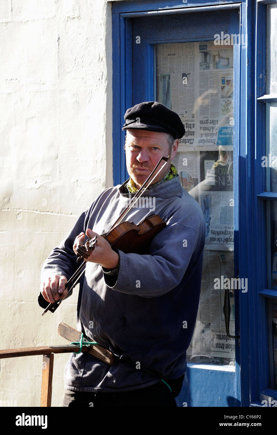 Busker rue de jouer d'un instrument de musique et le divertissement du grand public pour de l'argent dans les rues étroites de Whitby. Banque D'Images