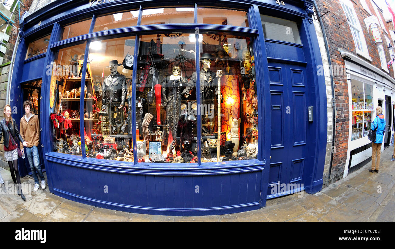 Jeune couple laissant un bay boutique fenêtré afficher les vêtements et marchandises visant principalement à la culture de Goth basé à Whitby. Banque D'Images