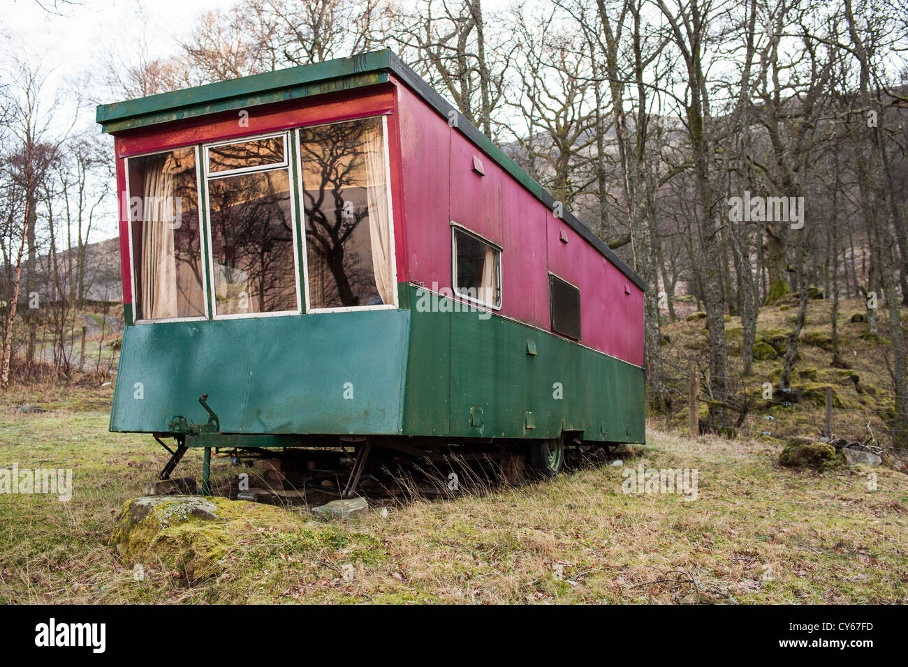 Caravane statique rouge et verte située dans les bois sur la rive sud du Loch Earn, dans le Perthshire, en Écosse. Banque D'Images