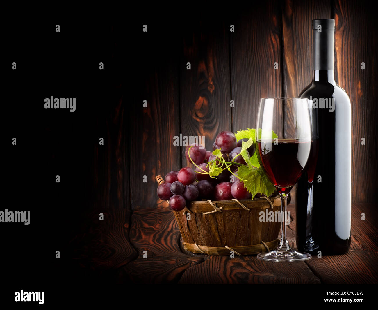 Vin rouge avec un verre de vin sur fond de bois Banque D'Images