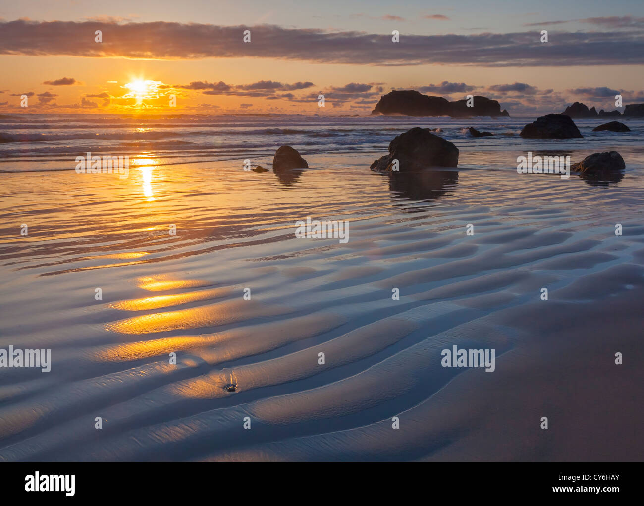 Parc d'état de Bandon, Oregon : réflexions Coucher de soleil à marée basse avec la silhouette du seastacks à Bandon Beach Banque D'Images