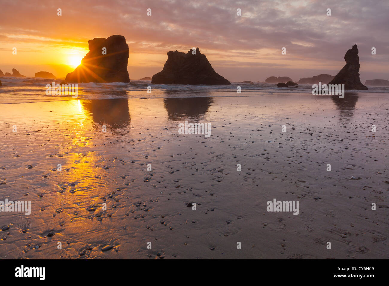 Parc d'état de Bandon, Oregon : réflexions Coucher de soleil à marée basse avec la silhouette du seastacks à Bandon Beach Banque D'Images