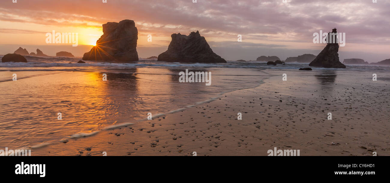 Parc d'état de Bandon, Oregon : réflexions Coucher de soleil à marée basse avec la silhouette du seastacks à Bandon Beach Banque D'Images
