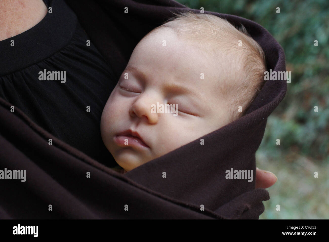 Un petit bébé qui dort en l'enveloppant dans une écharpe Photo Stock - Alamy