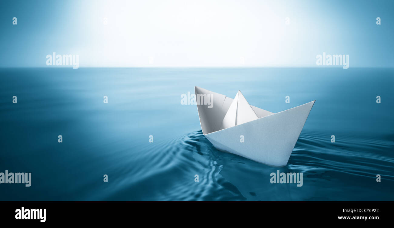 Origami Papier voilier naviguant sur l'eau bleue Banque D'Images
