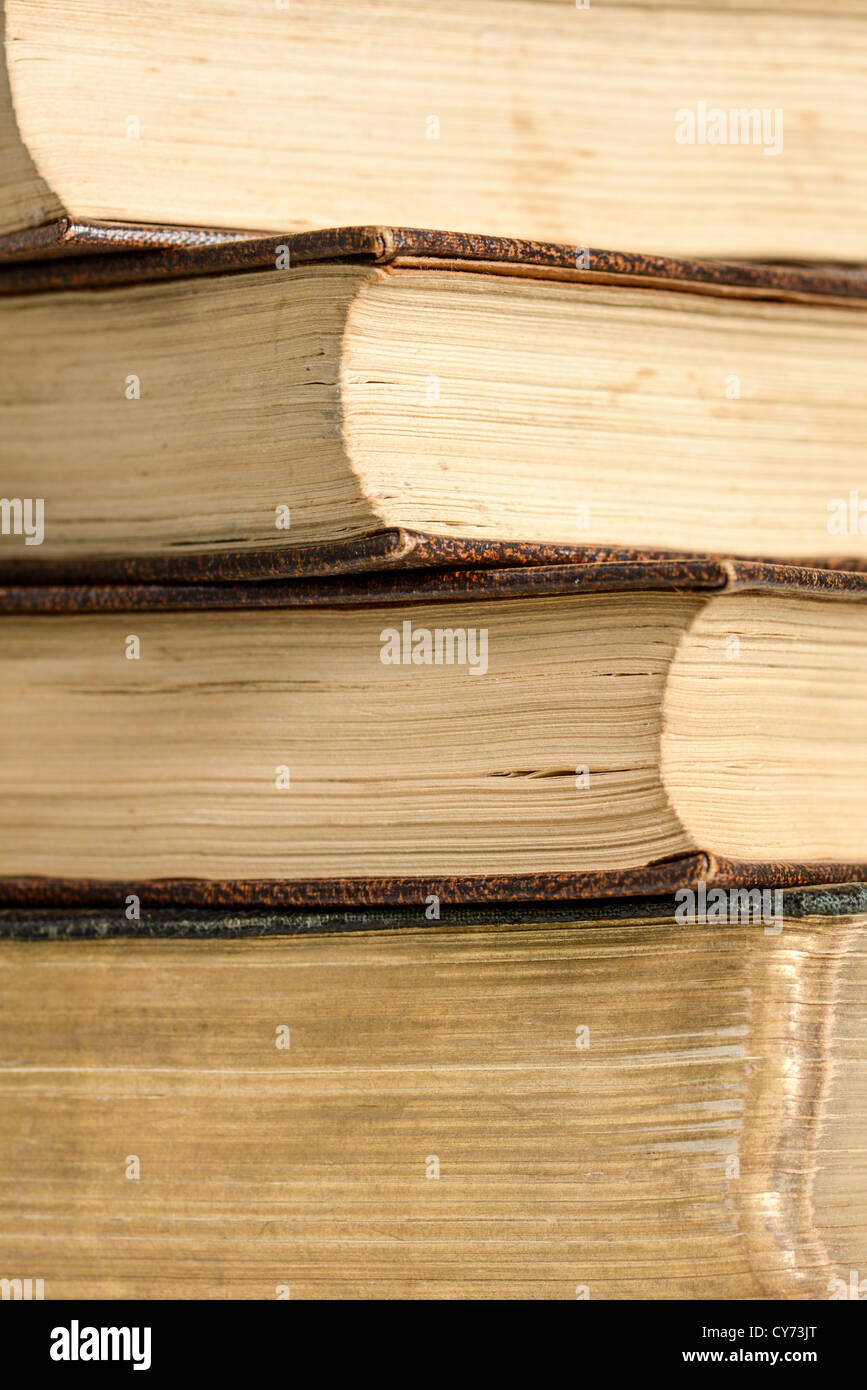 Une pile de quatre objets decoratifs anonyme anonyme anonyme books montrant des signes d'usure de la pages visibles Banque D'Images